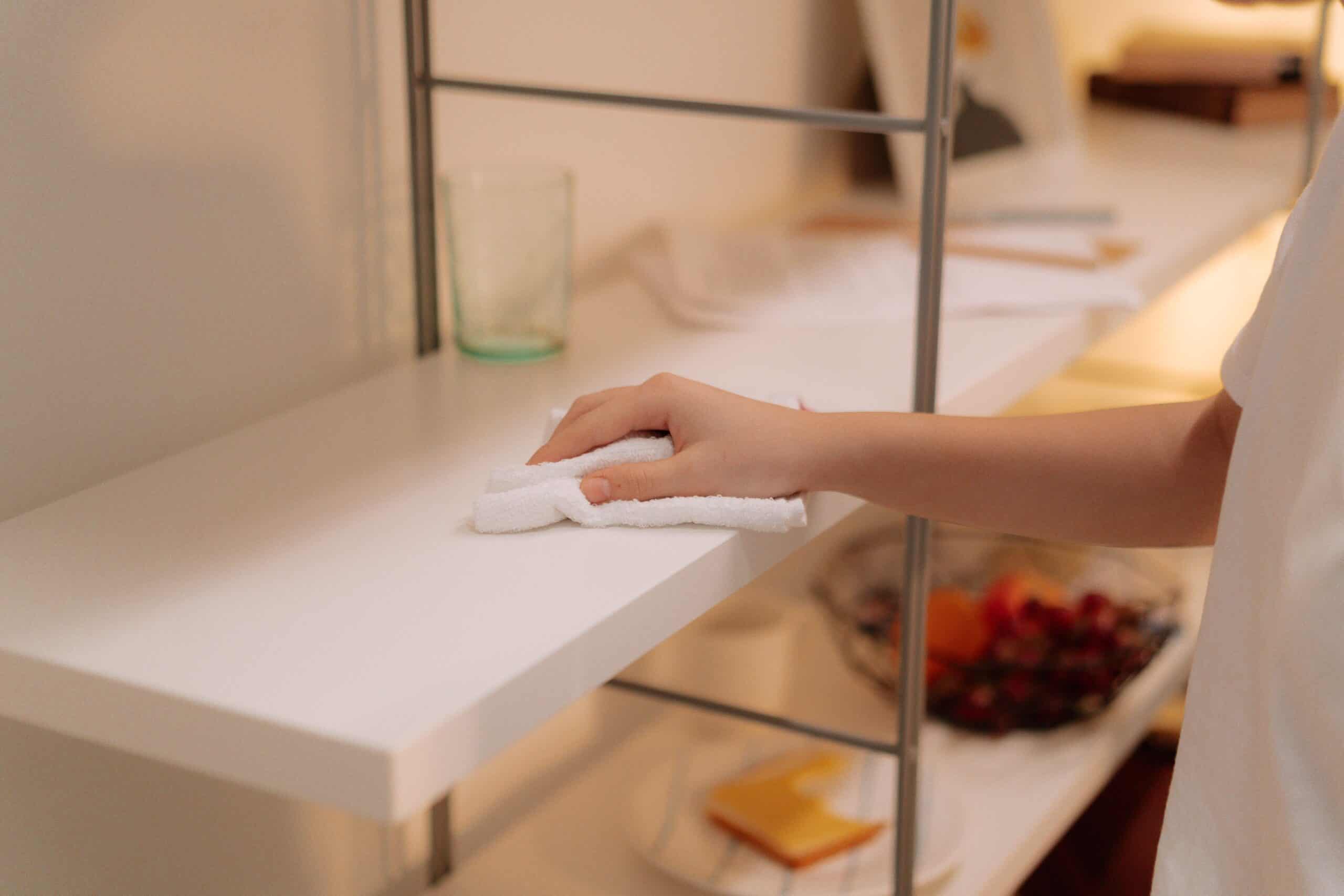 Carefully wiping a shelf clean